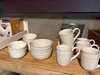Mugs, cereal bowls, and small embossed bowls on shelf