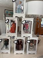 Group of six dolls each in white display case