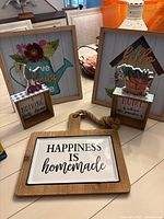 Overall shot showing two framed prints, two block signs, paddle sign