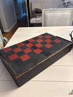 Closed wooden box with checkerboard top showing edge wear