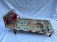 Side view showing clear plastic body, red shooter housing, four red legs