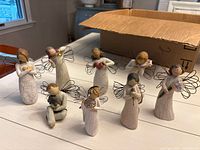 All eight Willow Tree angel figurines displayed on tabletop
