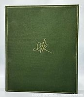 Front cover of green cloth hardcover with gilt monogram