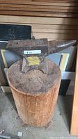 Anvil on wood stump full view