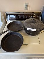 Overall view of two skillets and Dutch oven on appliance top