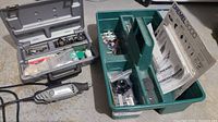 Overall view of rotary tool, grey accessory case open, green tray with accessories and manuals