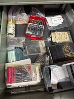 Drawer view showing multiple drill bit sets, spot weld cutter bag, driver extension