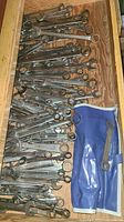 Drawer filled with numerous wrenches and blue vinyl pouch