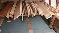 Stacked maple boards and offcuts on shelf, showing variety of lengths and widths