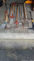 All nine long-handled tools laid out on floor