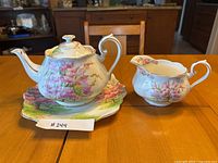 Teapot, square plate and gravy boat displayed together on table
