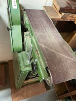 Side view of green combination belt sander, showing 6 in wide belt on machine