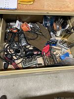 Drawer view showing corded drills, drill bits, hole saw, bit holders