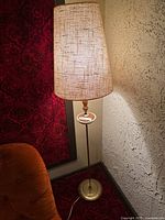 Full view of vintage floor lamp beside wall and chair