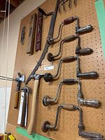 Pegboard with levels, blade, braces, hammers visible