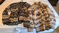 Both sweaters laid out showing patterns and styles