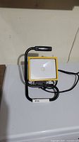 Front view of yellow portable LED work lamp on stand