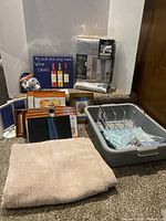 Group shot of all items on staircase including rug, curtain panels, frames, sign, sensor light, dish tub with rack and hooks