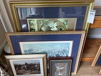 Stacked framed artworks showing range of sizes and styles