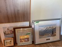 Group shot of five framed artworks leaning against wall