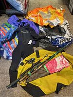 Lot overview showing wetsuit, inflatables, rods, reel, pump