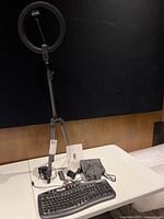 Ring light assembled on tripod; keyboard and accessories on table