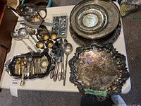 Overview of platters, utensils, teapot and flatware on table