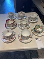 All eight teacup and saucer sets on table