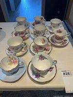 All ten teacup and saucer pairs laid out on table