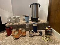 Group shot of entire lot showing coffee maker, multiple mugs, accessories and napkin rings