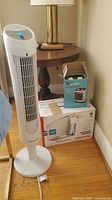 Honeywell tower fan beside stacked heater and humidifier boxes
