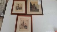 Overview of three framed Bruges architectural prints on table