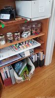 Overall view of shelf showing rack with spools, jars and other supplies