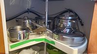 Multiple stainless steel pots and pans on turntable