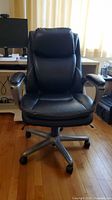Front view of black Serta high-back office chair showing upholstery and silver arms