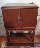 Front view of closed wooden bar cabinet on open base