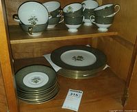 Cabinet view showing teacups and stacked dinner plates