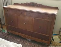 Front view of buffet showing overall design, drawers, doors, hardware, and backsplash