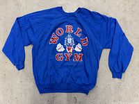 Back view of royal blue long-sleeve shirt showing large World Gym graphic