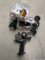 Kyosho buggy and pistol-grip transmitter on floor