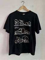 Full view of black T-shirt on hanger showing front graphic