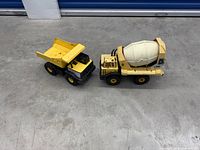 Dump truck and cement mixer side view
