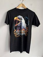 Full view of black Harley-Davidson eagle graphic T-shirt on hanger