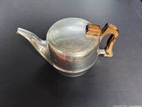 Top view of aluminium kettle showing lid and wooden handle