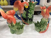 Pair of macaw candlesticks with matching pitcher behind