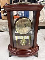 Front view of Bombay Company mantle clock showing dial and pendulum