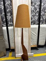 Full view of floor lamp showing wood column, base, and textured drum shade