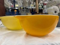 Side view of yellow and orange Pyrex Cinderella bowls showing color and shape