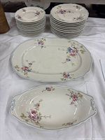 Overall lot showing stacks of dinner and luncheon plates plus two serving platters