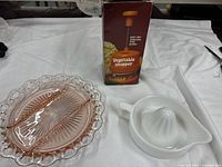 Group shot of plate, juicer and boxed chopper